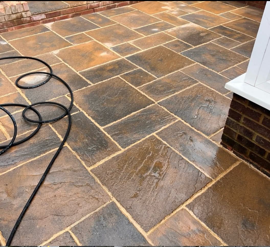Indian sandstone patio freshly jet-washed and glistening wet