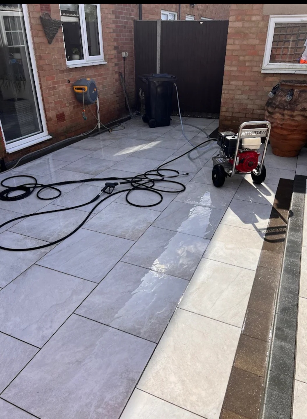 Porcelain patio being pressure washed with Watertek machine