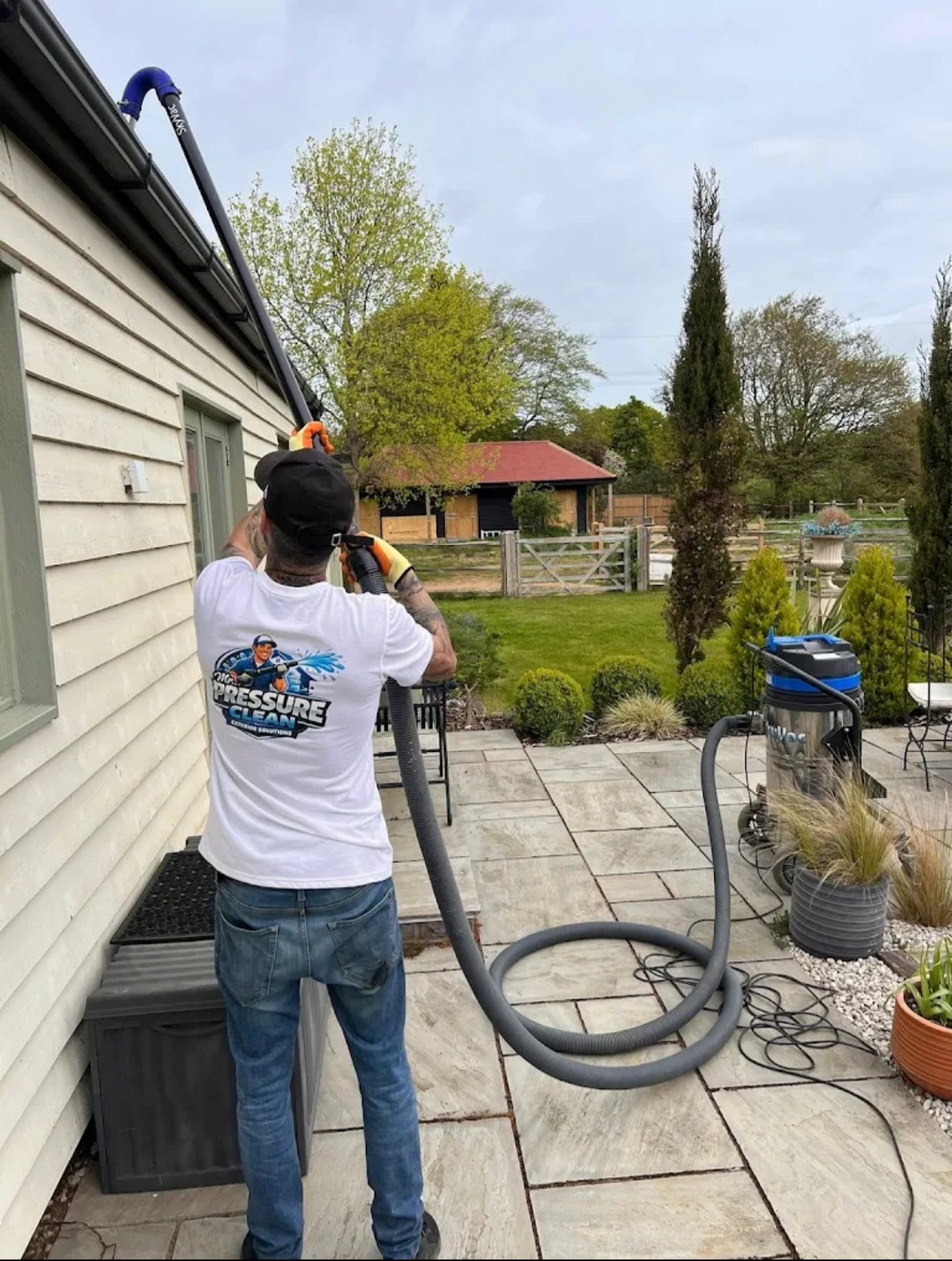 Mr Pressure Clean technician vacuuming gutters on a country property