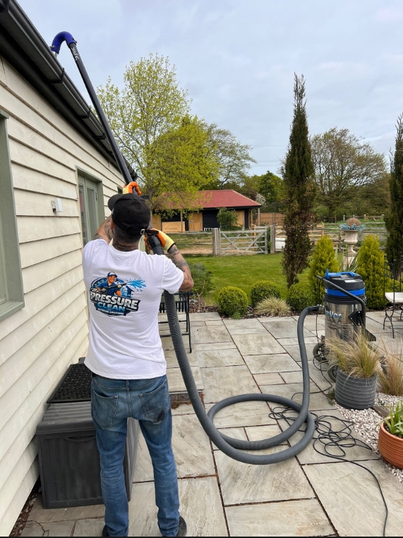 Mr Pressure Clean technician vacuuming gutters at a country home