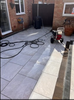 Grey slab patio mid-clean showing dramatic before and after