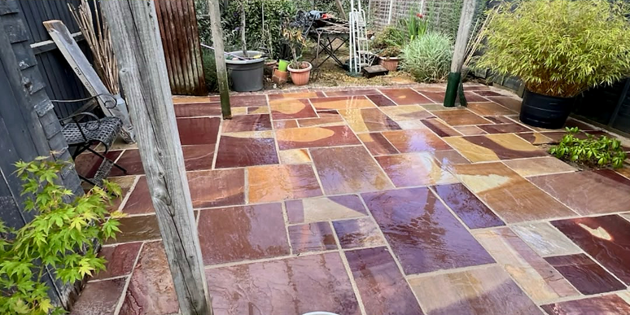 Patio beneath a wooden pergola before and after cleaning by Mr Pressure Clean Exterior Solutions — after
