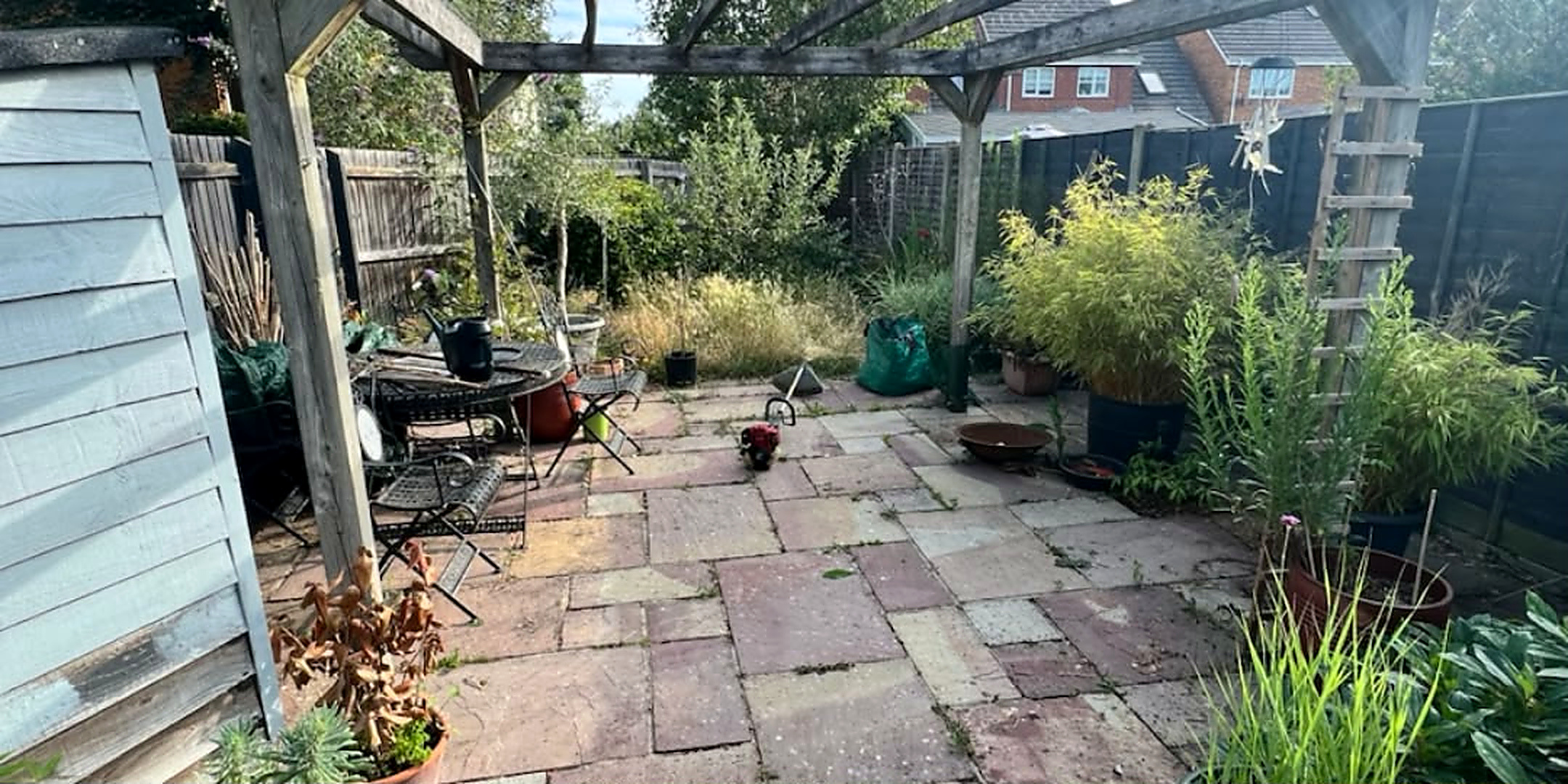 Patio beneath a wooden pergola before and after cleaning by Mr Pressure Clean Exterior Solutions — before