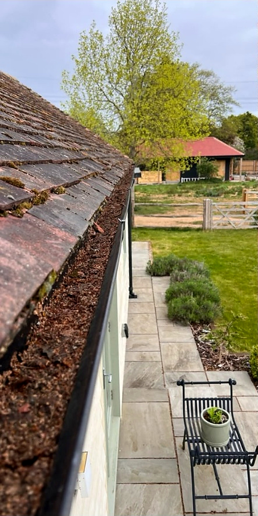 Gutter cleared of moss and leaf debris — before