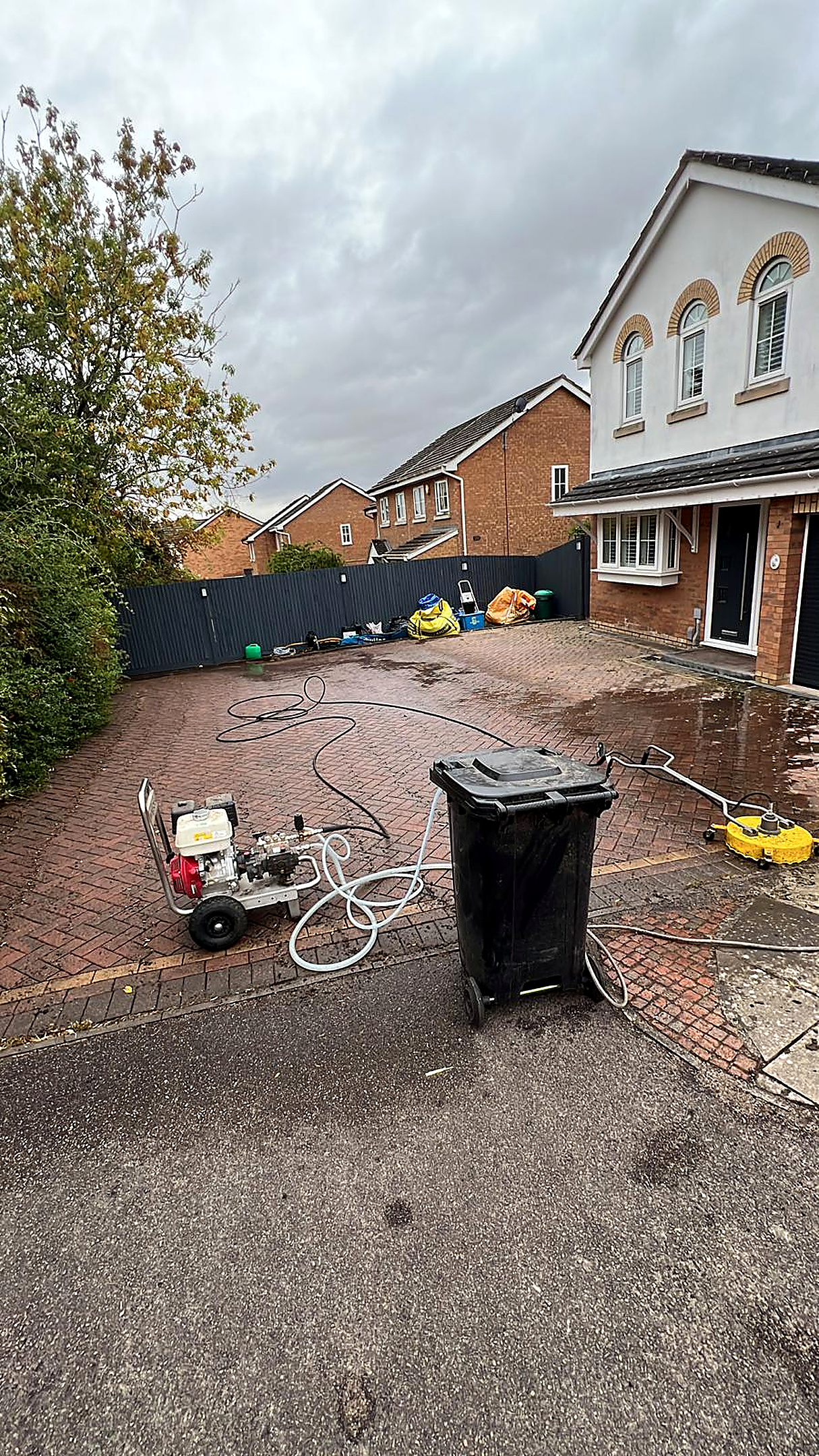 Block paved driveway before and after professional pressure washing — before